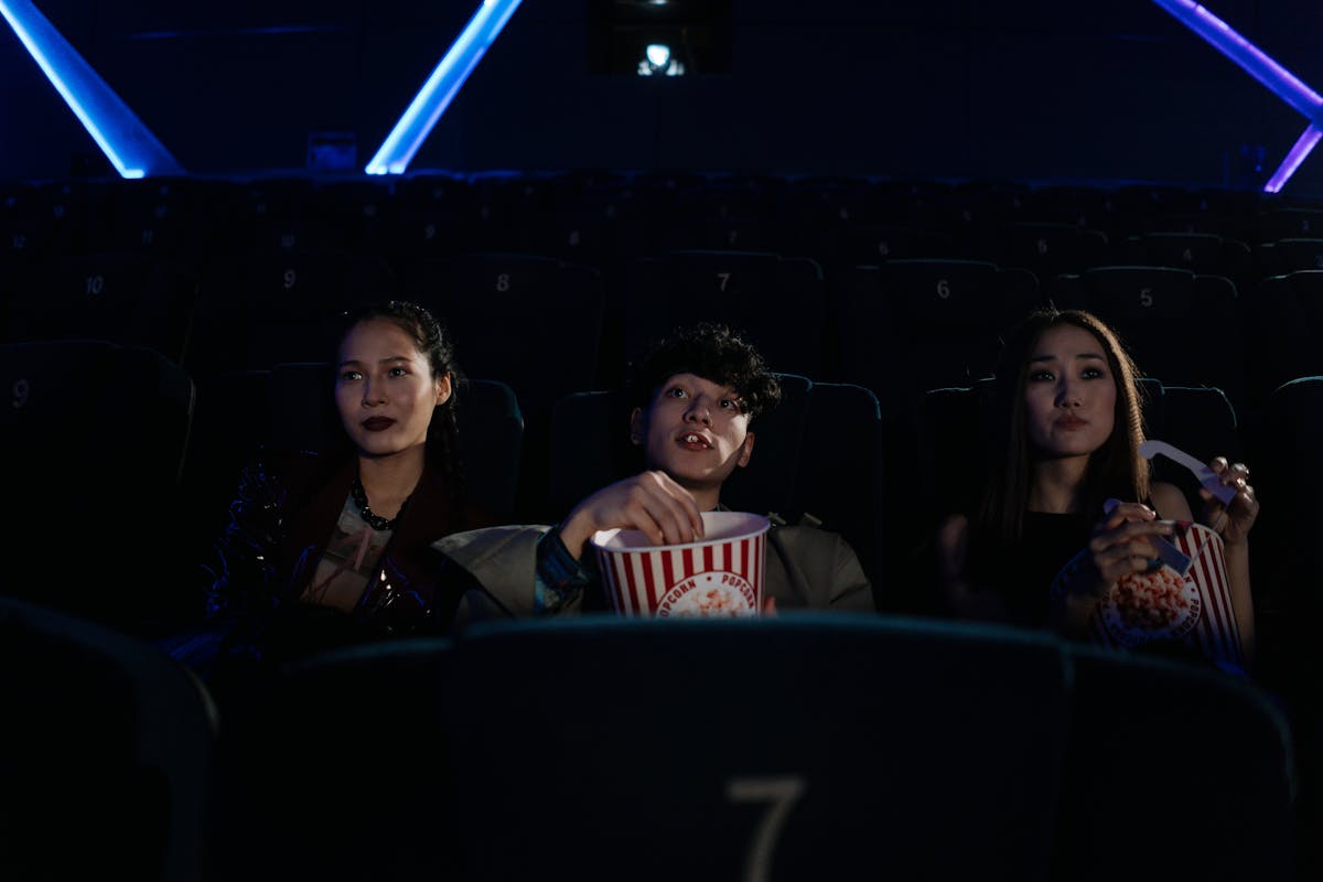 Groupe d amis riant ensemble au cinéma